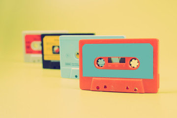 a large collection of retro cassette tapes places in a grid on green background
