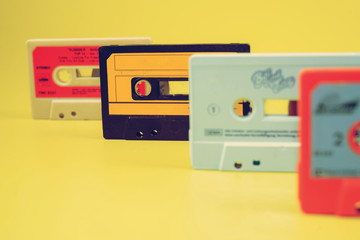 a large collection of retro cassette tapes places in a grid on green background