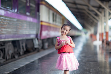 Obraz premium Child Journey by train on platform of railway station in thailand