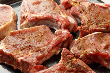 Fresh raw beef steak In spices on a baking sheet