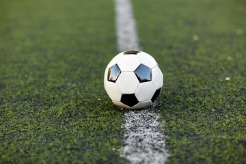 soccer ball on football field marking line