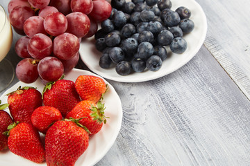 Berries and grapes on a gray wooden background