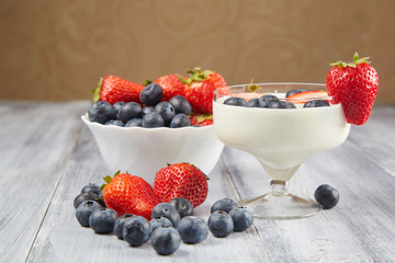 Strawberry, blueberry with yogurt on a gray wooden background