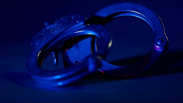 Handcuffs with Red and Blue Flashing Police Lights