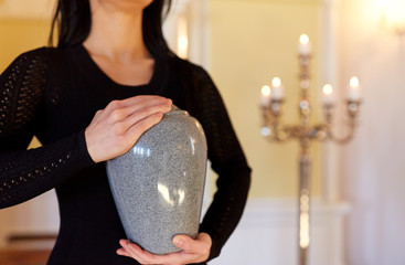 close up of woman with cremation urn in church