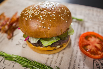 A fresh tasty burger with sliced tomato and bacon