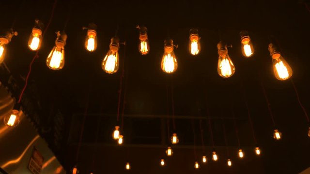 Light bulbs turned on. Vintage tungsten bulbs hanging from the ceiling
