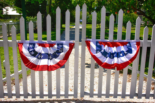 White picket fence gates with July 4th red, white and blue bunting celebrating Indepenence day in Florida