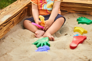 Little boy playing in the sand - close up photo of the sandy legs