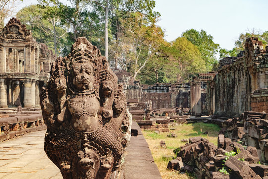 Naga serpent cobra king Vasuki in the foreground guarding Preah Khan Temple in Angkor Complex, Siem Reap, Cambodia. Ancient Khmer architecture and famous Cambodian landmark, World Heritage.