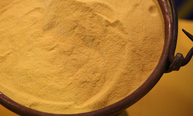Yellow flour in old copper cauldron