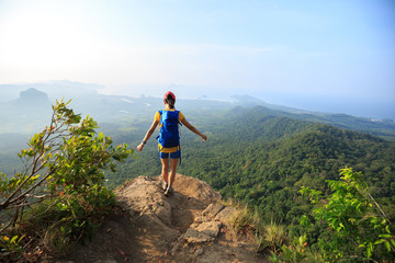 successful woman hiker hiking on mountain peak