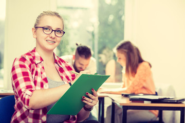 Student girl in front of her mates in classroom