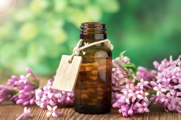 Essential oil of lilac in a glass bottle on a wooden , relaxation, Spa.