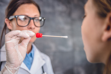 Female doctor taking a throat culture