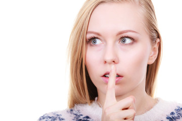 Young blonde woman making silence gesture