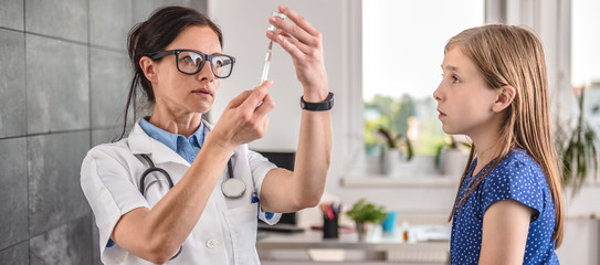 Doctor preparing a vaccine to inject into a patient