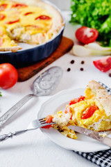 French open pie from short pastry, kish, tart with chicken, cherry tomatoes, greens and creamy cheese cress, filling, sauce and spices, pepper, lettuce and salt on white rustic background