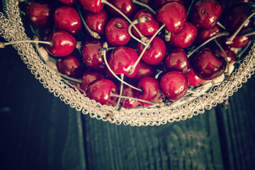 Ripe cherries in a bowl / Top view of bunch of cherries in a bowl on black background