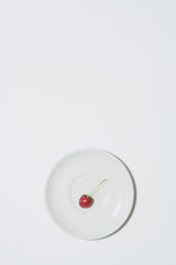 Minimal cherry background. Fruit on white plate. Vertical design for a leaflet, banner, cover or flyer