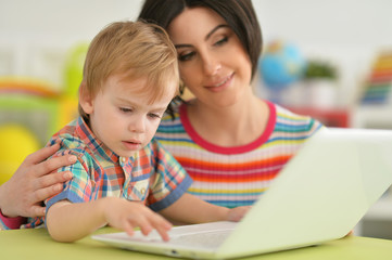Fototapeta na wymiar Mother and son using modern laptop