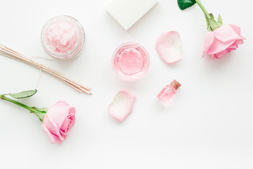 body treatment with rose flowers and cosmetic set white desk background top view space for text