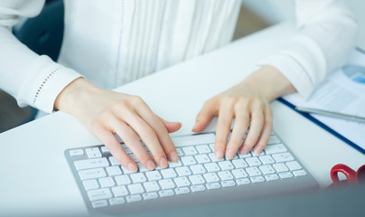 Closeup picture of female hands typing on desktop computer keyboard. Concept of freelance work.