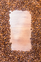 Spilled grains of fragrant coffee close-up. Photo frame, background.