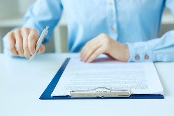 Hands of business woman signing the contract document with pen on desk. selective focus image on sign a contract.