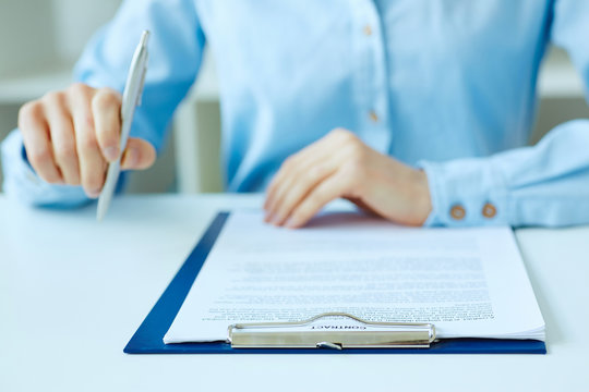 Hands of business woman signing the contract document with pen on desk. selective focus image on sign a contract.