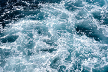 Fototapeta na wymiar Natural background of blue-green sea water with foam and waves.