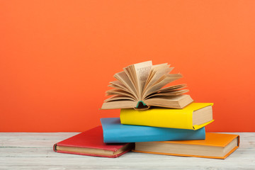 Open book, hardback colorful books on wooden table. Back to school. Copy space for text. Education business concept.