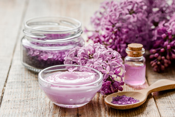 Obraz na płótnie Canvas lilac natural cosmetic set for spa with salt wooden table background