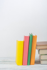 Book stacking. Open book, hardback books on wooden table and blue background. Back to school. Copy space for text.