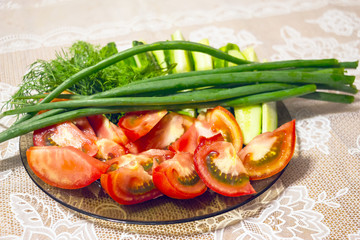 Sliced tomatoes and green onions on a plate. Fresh vegetables