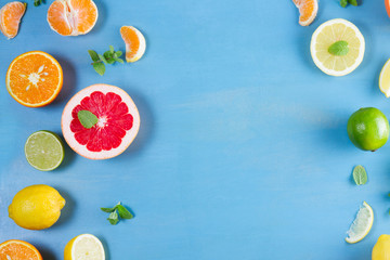 citrus food flat lay frame pattern on blue background - assorted citrus fruits with mint leaves