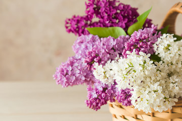 Beautiful, white, pink and purple lilac flowers in the basket. Cozy atmosphere with fresh, fragrant flowers.
