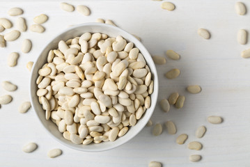 Dry white bean legumes in white bowl