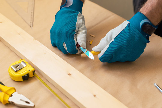 Carpenter handyman sharpening pencil with pocket knife