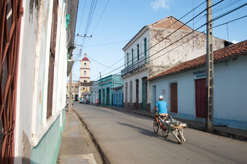 man on bicycle riding into town