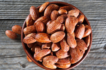 Top view of hickory smoked almonds in a small bowl on a wood table.