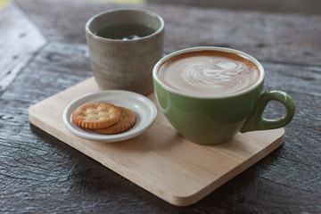 hot coffee latte on wood plate.