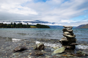 rocks by the shore with mountains