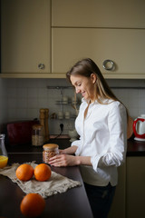 Smiling woman holding a jar of granola, healthy breakfast, morning