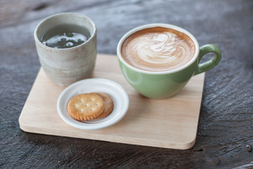 hot coffee latte on wood plate.