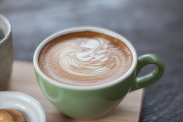 hot coffee latte on wood plate.