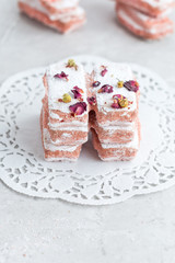 Pink Ladyfinger Biscuits Stacked on Doily and Sprinkled with Rose Petals