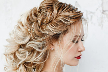 Schöne Frau mit gefärbten Haaren mit Abendfrisur griechischer Zopf