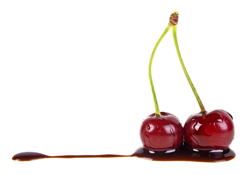 Two cherries in chocolate on a white background