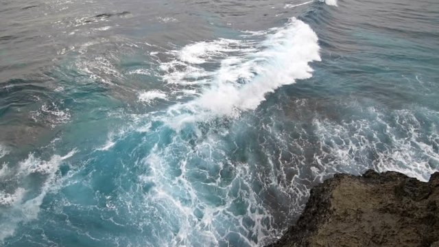 Sea waves explode on the rocky shore slow motion
